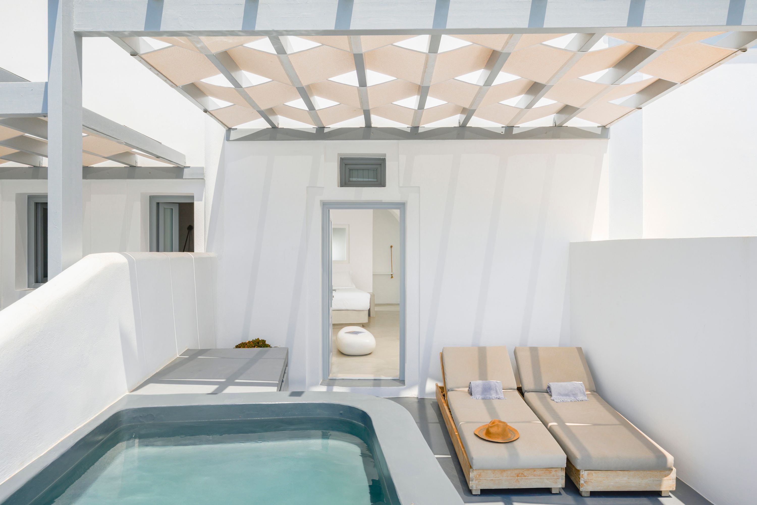 Ein moderner Wellnessbereich mit Whirlpool, zwei Liegen und einem privaten Badezimmer.