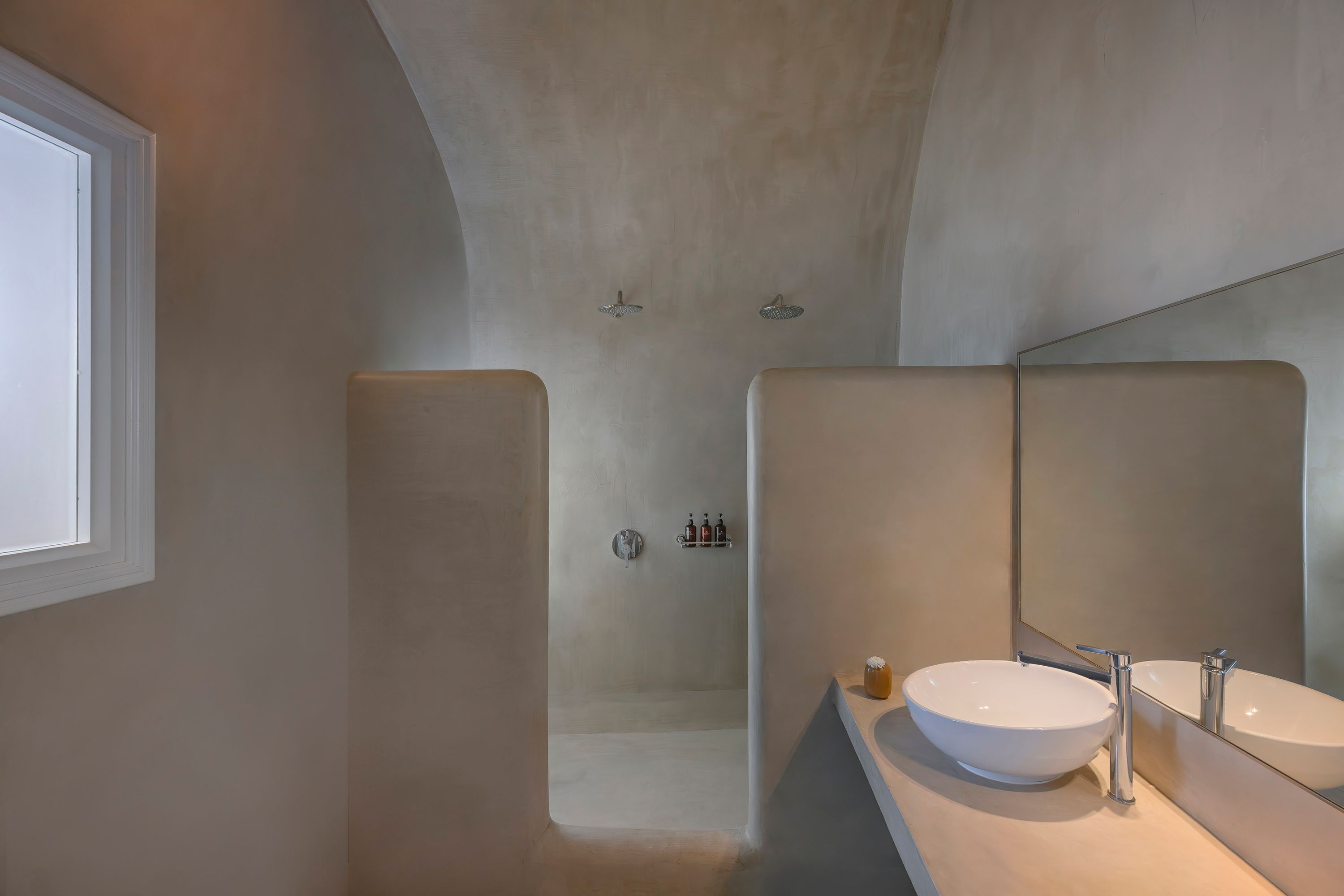 Un baño moderno con un espejo grande, un lavabo blanco y una zona de ducha.