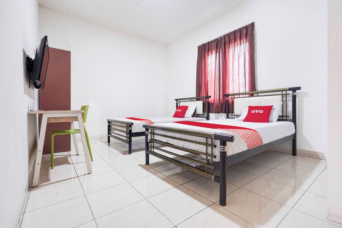 A hotel room with a bed, a desk, and a chair.