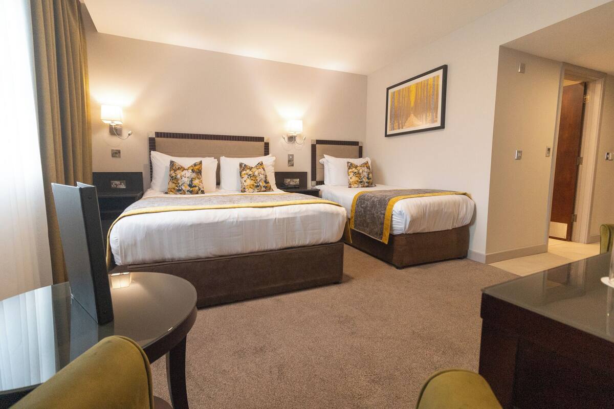 Una habitación de hotel con dos camas, un escritorio y una silla.