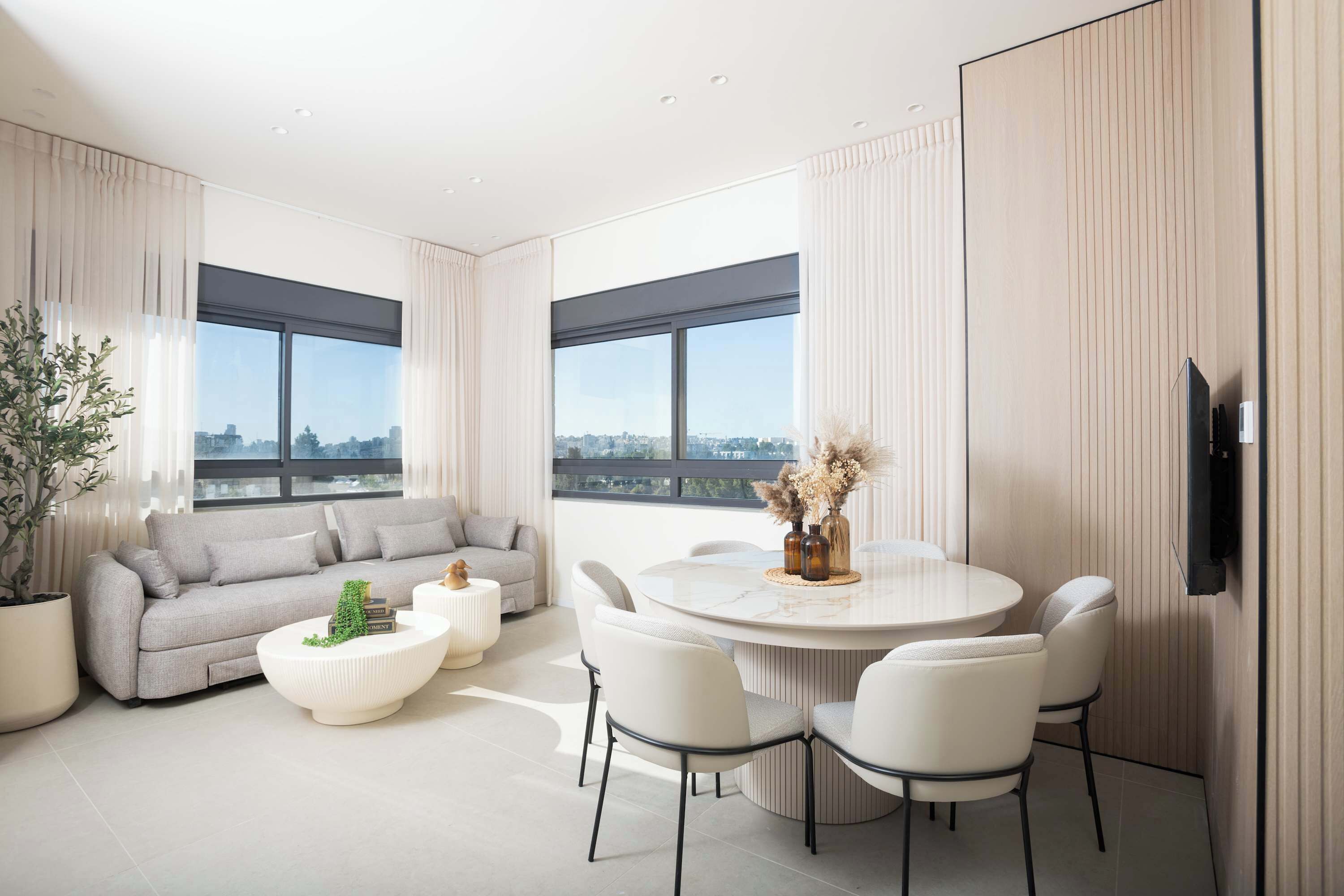 A modern living room with a sofa, coffee table, and dining table with chairs.