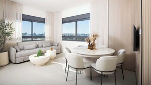 En moderne stue med sofa, sofabord og spisebord med stole.