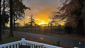A deck with chairs overlooking a road and a sunset. - Wl34 Caravan Haggerston Castle Private Decking (Berwick-upon-Tweed)