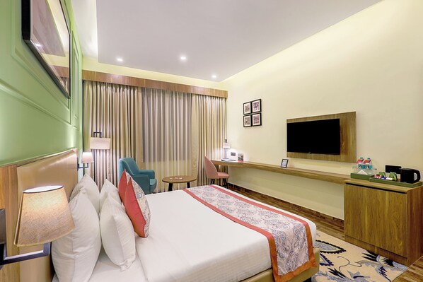A hotel room with a bed, a desk, a chair, a television, and a window with curtains. - Sterling Bagh Ranthambore (Sawai Madhopur)