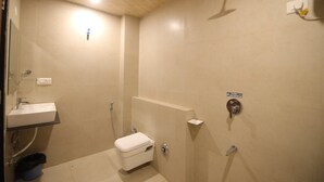 Un baño pequeño y funcional con inodoro, lavamanos y ducha.