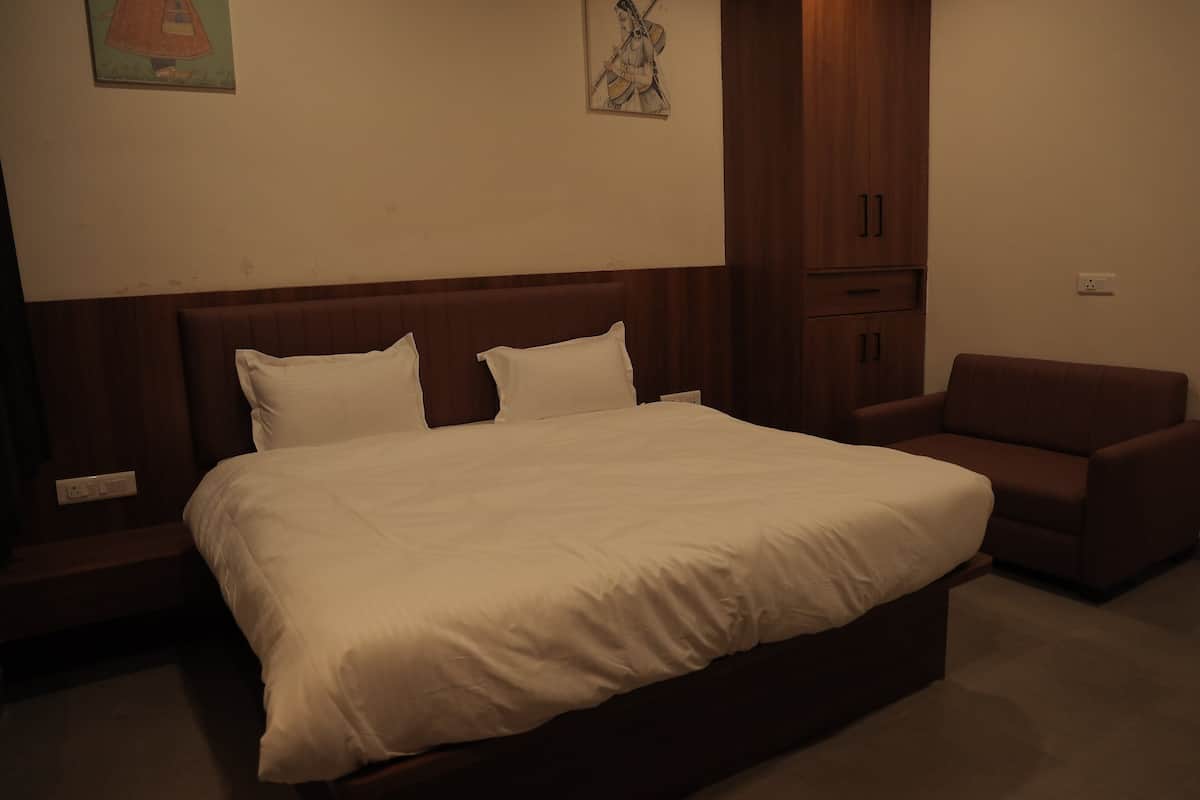 A neatly made bed with white linens in a hotel room.