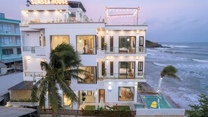 Un hôtel à plusieurs étages doté d’une piscine, appelé « Sunsea House », qui offre une vue sur l’océan.
