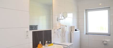 Regadera, secadora de cabello, jabón, papel de baño