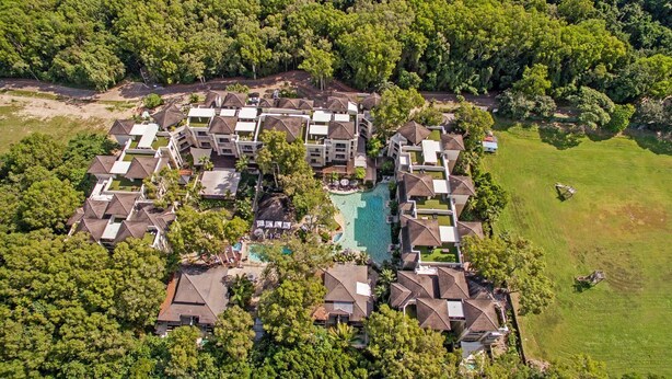 An aerial view of a resort with multiple buildings, a central swimming pool, and surrounding greenery. - Temple 2 Bedroom Dual Key with Rooftop Terrace 422/3 (Palm Cove)