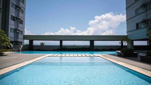 Une piscine offrant une vue sur le paysage urbain et les montagnes au loin.