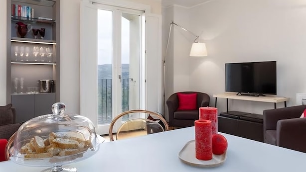 Una sala de estar moderna con comedor, televisor y balcón con vistas.