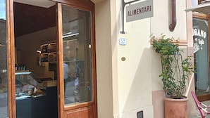 Una fachada con un letrero que dice "ALIMENTARI" y el número "57" encima.