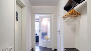 A hallway with a ceiling light, a radiator, a bench, and a door leading to another room. - Apartment for 2 p. + toddler, central and close to the beach, fireplace, sauna, terrace, WLAN (Prerow)