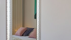 A bedroom with a bed, pillows, a bedside table, and a mirror. - Terra Magica Room with Private Parking (Cavle)