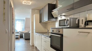 Eine moderne Küche mit Mikrowelle, Kaffeemaschine und Backofen.