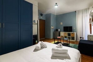 Une chambre d’hôtel équipée d’un lit, d’une télévision, d’un bureau et d’une armoire.