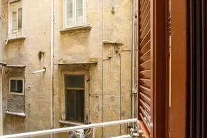 A view of a building with multiple windows and a door. - Il Vicoletto a Chiaia (NAPOLI)