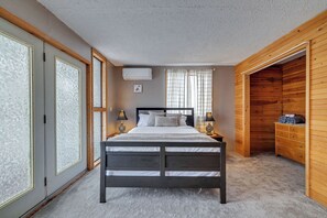 Cozy bedroom with a central bed, wooden wardrobe, and bedside lamps.