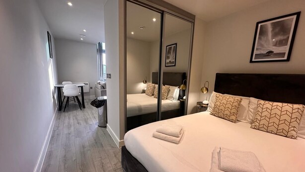 A modern hotel room with a large bed, a desk, and a chair. - Cozy Studio in Bracknell with free Parking (Bracknell)