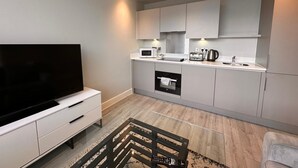A modern kitchen with a built-in oven, microwave, and kettle. - Cozy Studio in Bracknell with free Parking (Bracknell)