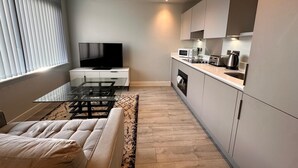 A modern kitchen with a flat-screen TV, built-in oven, microwave, and kettle. - Cozy Studio in Bracknell with free Parking (Bracknell)