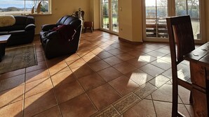 Un salón amplio con un gran ventanal, chimenea y comedor.