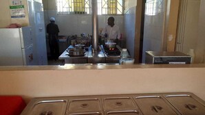 Una cocina con encimeras de acero inoxidable, una estufa y una persona cocinando.