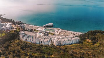 An aerial view of a coastal hotel with multiple buildings, a swimming pool, and a beach area.