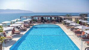 A poolside area with lounge chairs and umbrellas, overlooking a body of water. - Hotel Vlora Priam, Affiliated By Meliá (Vlorë)
