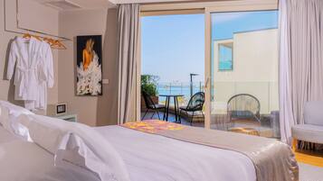 Une chambre d’hôtel avec un lit, une chaise, une table et un balcon offrant une vue.