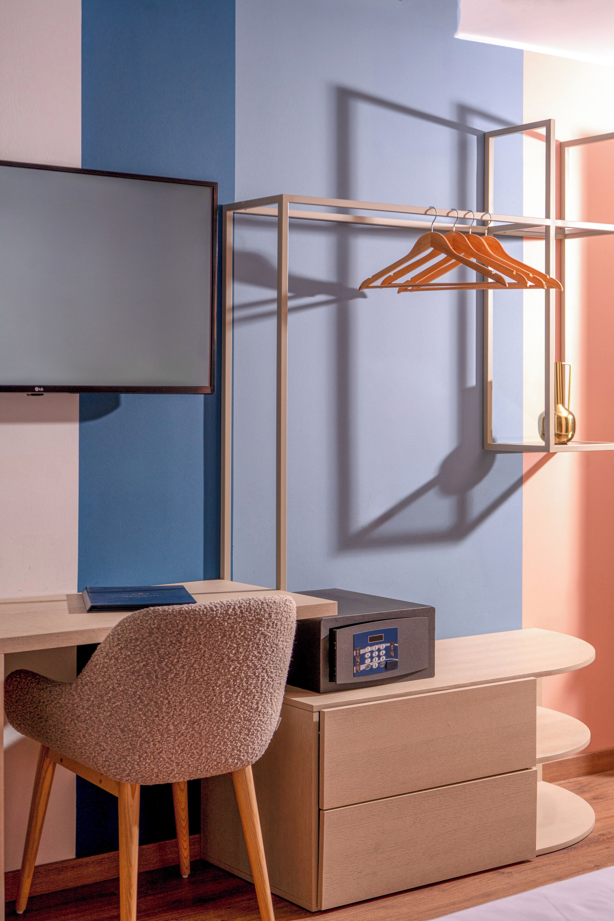 A modern room with a desk, chair, and a safe.