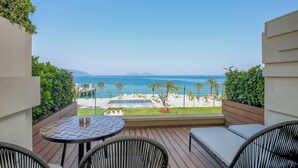 A balcony with a view of the sea, a pool, and a lounge area with wicker chairs and a table. - Hotel Vlora Priam, Affiliated By Meliá (Vlorë)