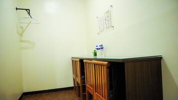 A small room with a wooden bench, a table, and a wall-mounted rack.