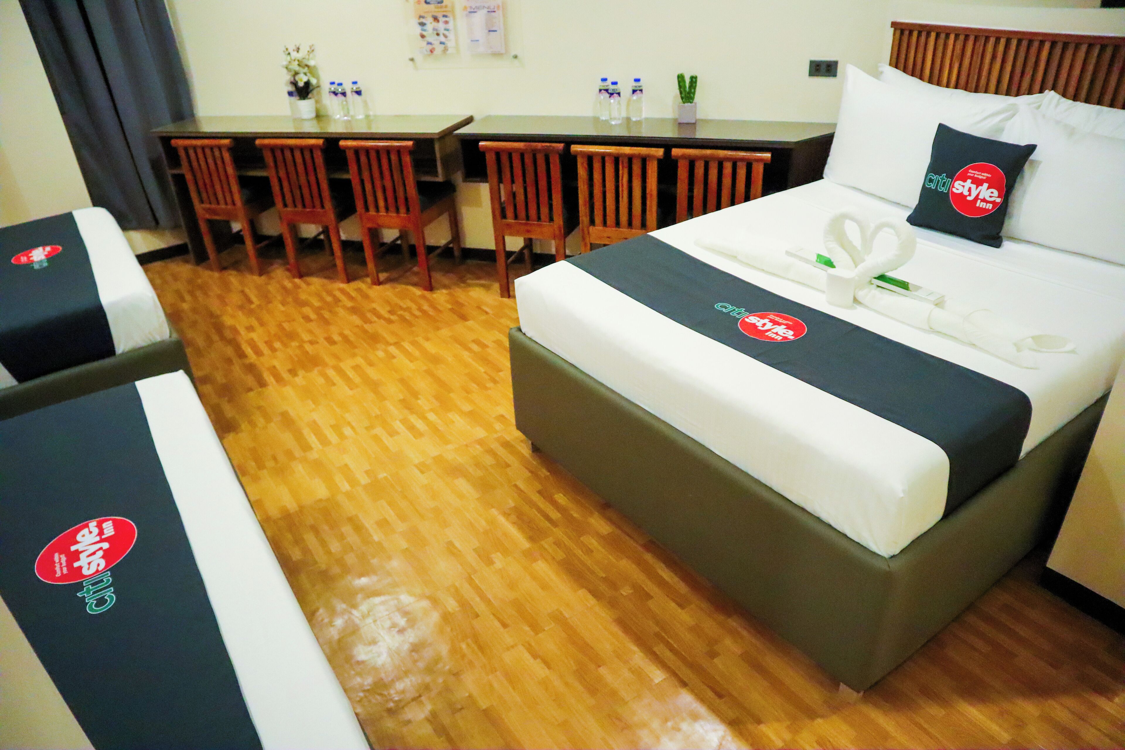 A hotel room with a bed, a desk, and four chairs.
