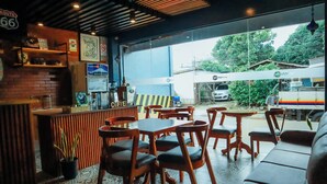 A café with wooden furniture, a coffee bar, and a view of the street outside. - CITISTYLE INN INC. (Davao)