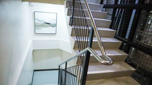 A staircase with metal railings and a handrail, leading to a lower floor. - CITISTYLE INN INC. (Davao)