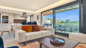 Una sala moderna con un sofá, una mesa de centro y un comedor con sillas y una mesa.