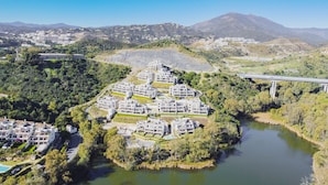 Vista aérea de una zona residencial con edificios modernos, un río y un puente al fondo.