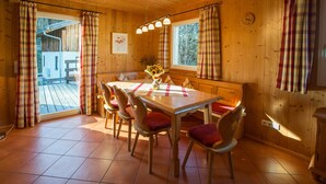 Ein Esszimmer mit Holztisch, Stühlen und einer Vase mit Sonnenblumen.