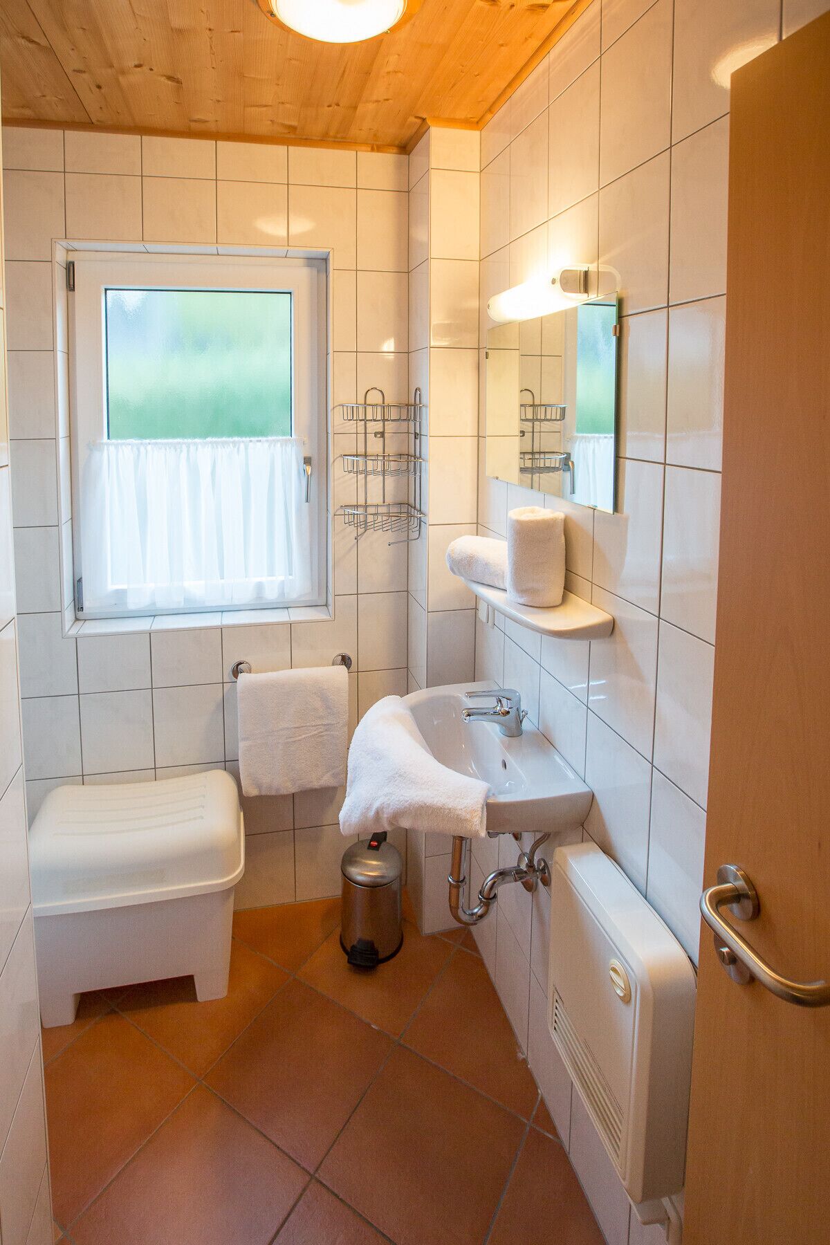A compact bathroom with a toilet, sink, and window.