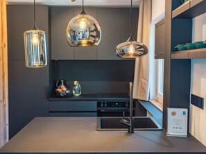 A modern kitchen with pendant lights, a built-in oven, and a stainless steel faucet. - Superior Chalet # 61 with 3 BR and IR-Sauna (Annaberg)