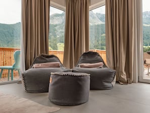 Un balcon avec deux fauteuils en forme de sac de haricots et une vue sur les montagnes.