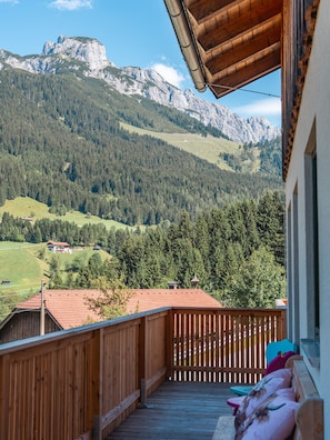 Un balcón de madera con vistas a un paisaje montañoso.