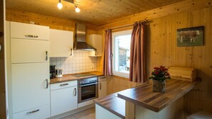 A kitchen with white cabinets, a wooden countertop, a stove, and a sink.