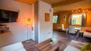 A modern interior with a sofa, coffee table, and a TV mounted on the wall.