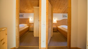 A room with two wooden bunk beds, a carpeted floor, and a wooden ceiling. - Chalet # 04 with 3 BR for 6 to 8 people (Annaberg)