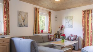A cozy living room with a sofa, a small table, and a bookshelf.