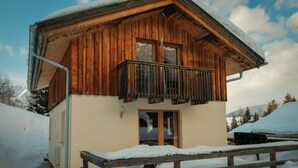A wooden cabin with a balcony, surrounded by snow. - Chalet # 92 with 3 BR for up to 6 people (Annaberg)