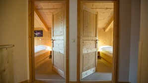 Habitación con dos camas, paredes de madera y suelo alfombrado.