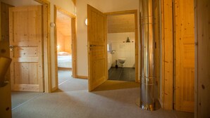 Un intérieur en bois avec une chambre, une salle de bain et un couloir menant à une autre pièce, le tout visible.